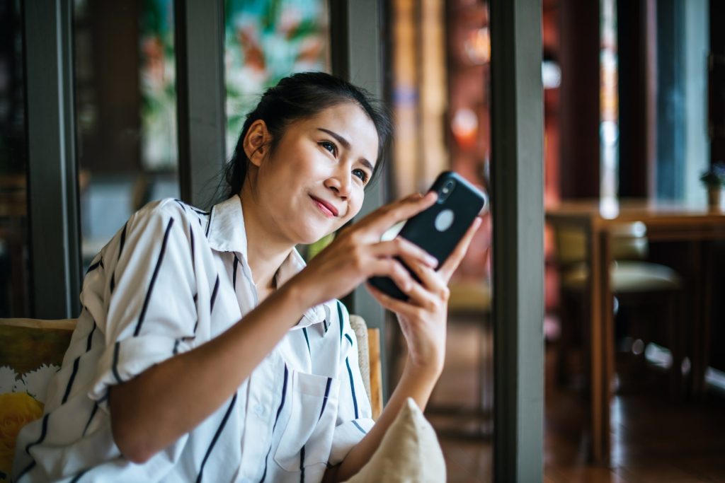 Woman Sitting Playing Her Smart Phone Cafe